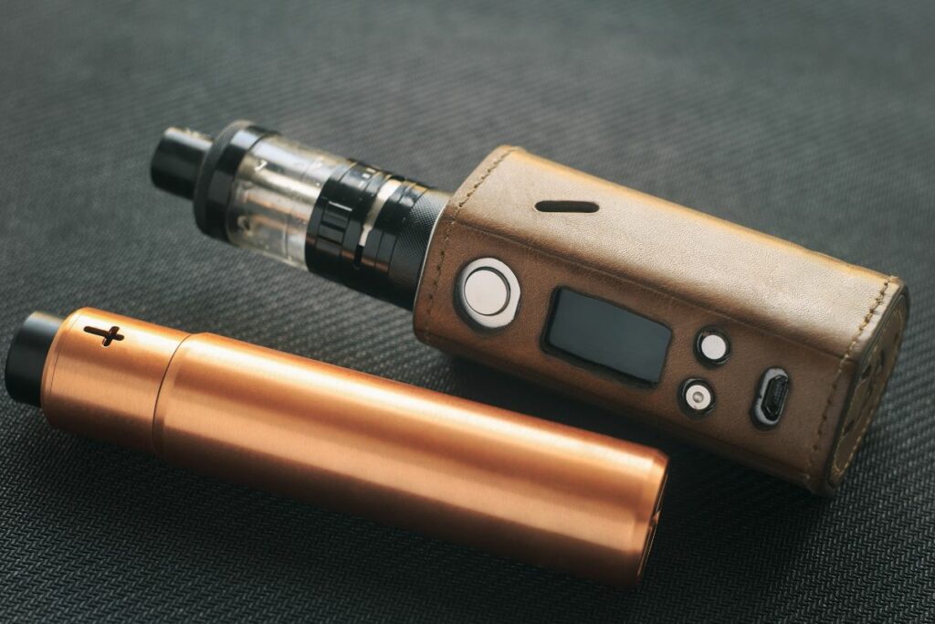 A close up of two vaping devices on a table.