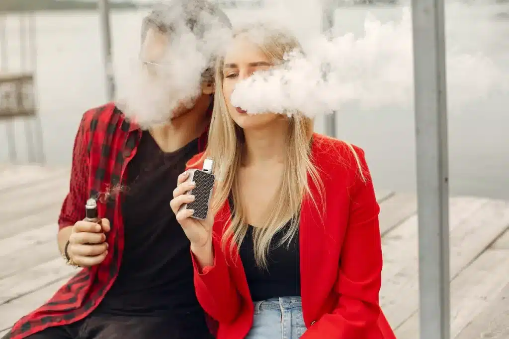 A guy and a girl vaping