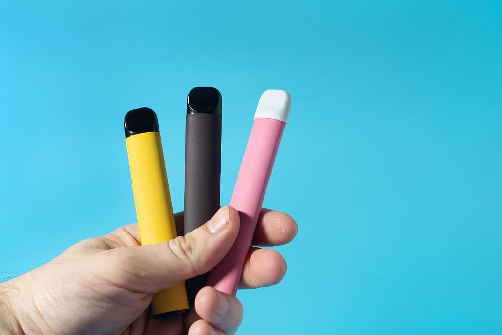 A man holding Disposable Vapes