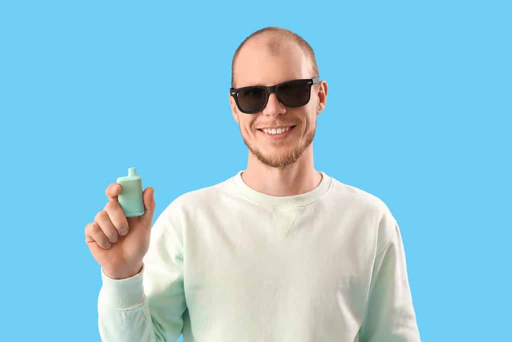 A guy holding vaping device in his hand