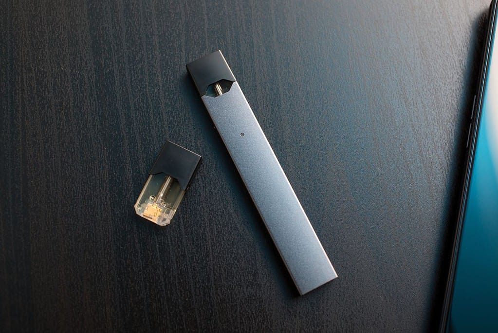 A JUUL pod sitting on top of a wooden table