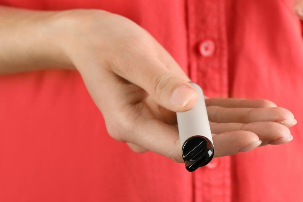 A person holding a small device in their hand.