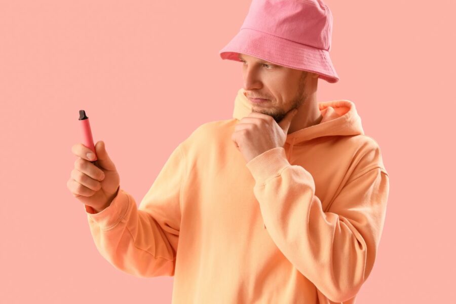 A man holding a hot disposable vape in his hand