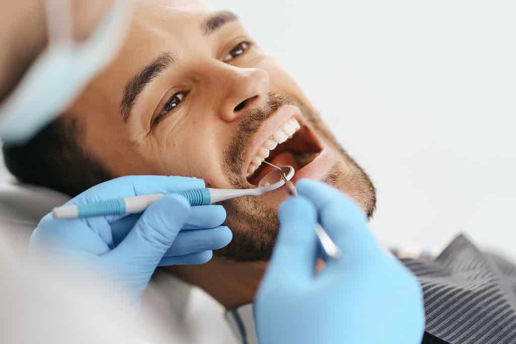 A dentist checks if a man vapes during his teeth examination.