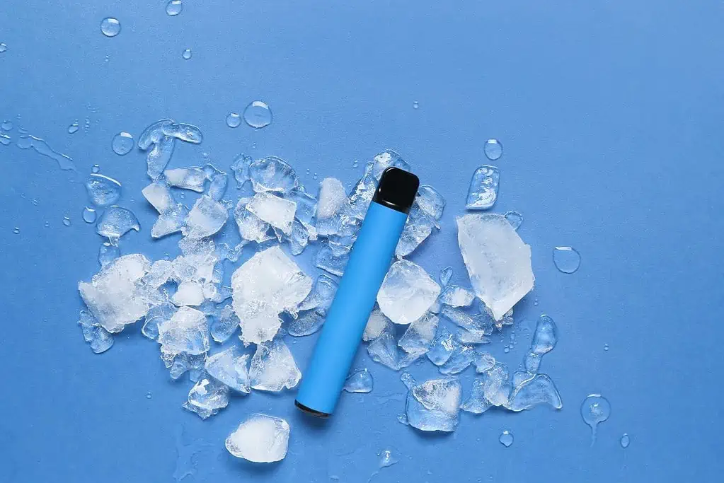 A blue e cigarette with ice pieces on a blue background that indicates when the elf bar is empty.