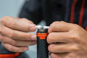 A guy cleaning vape coil of his vaping device