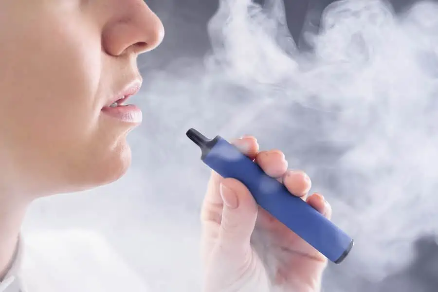 A lady using disposable vape and checking how long will it last