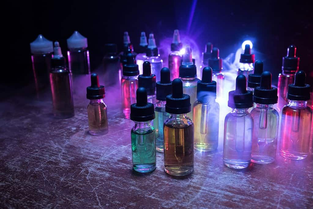 A table with a variety of e liquid bottles.