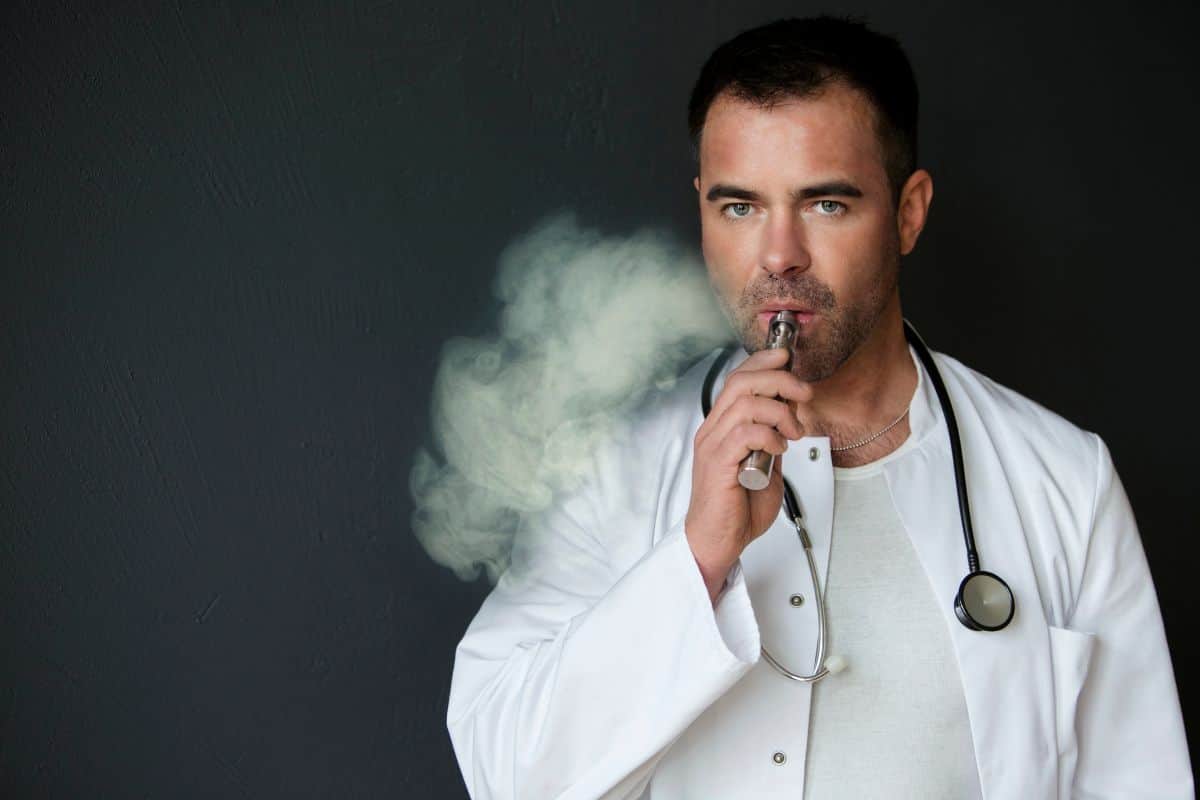Handsome doctor smoking with e cigarette