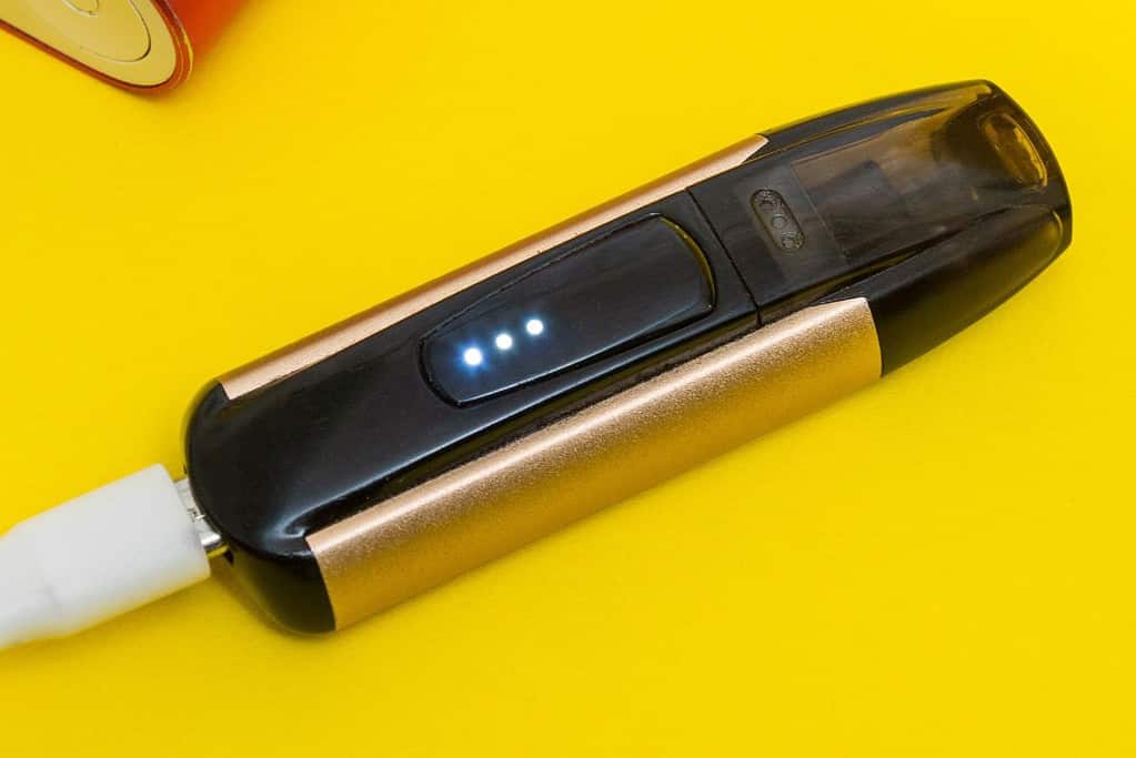 Vape device getting charged and showing three blue lights