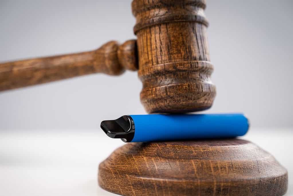 An unconventional gavel topped with a blue cigarette drawing attention.