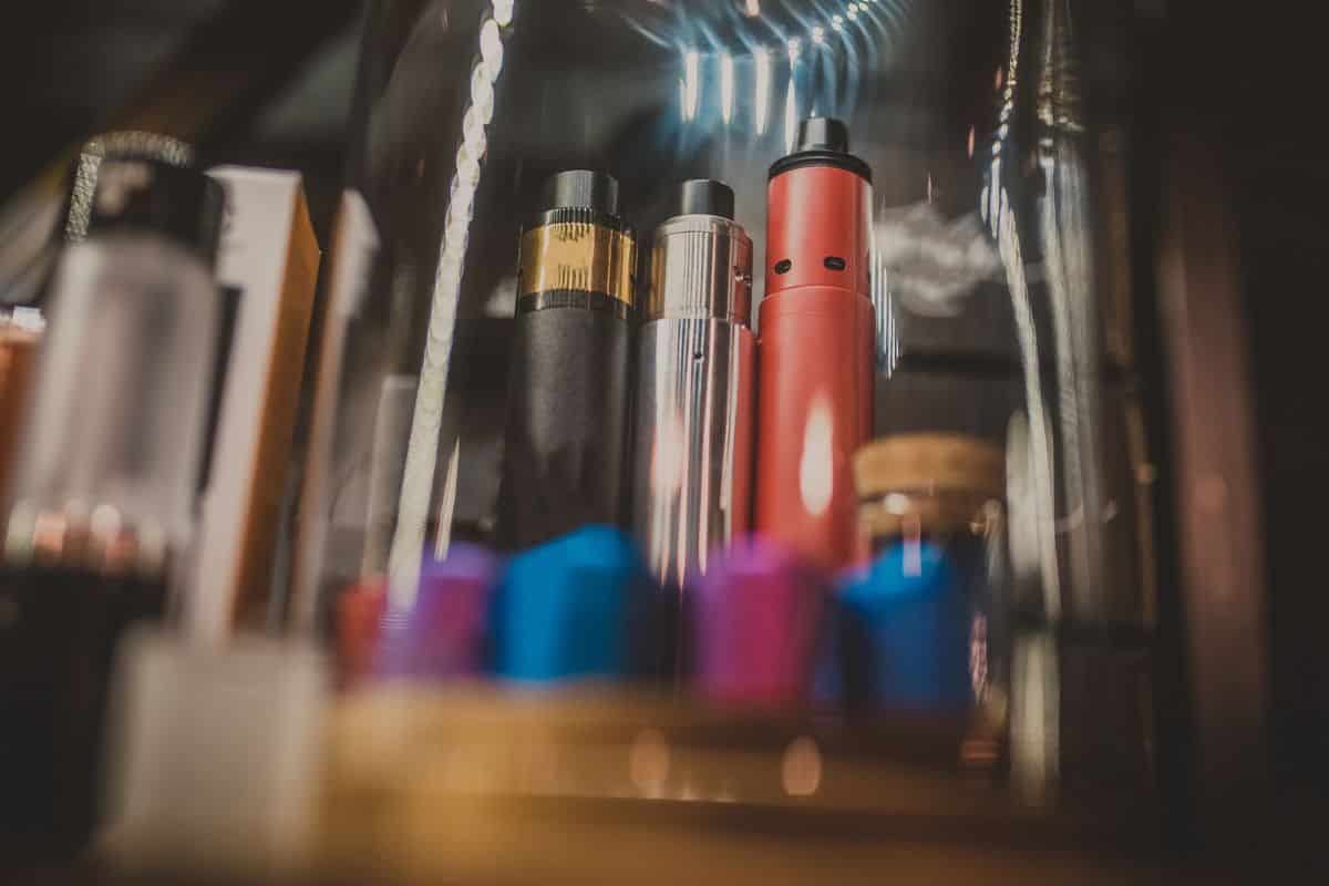 E cigs with best vape pens for cartridges displayed in a glass jar on a shelf.