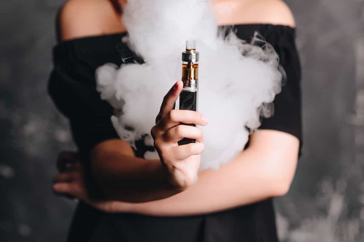 A lady holding a vaping device with ohms too high