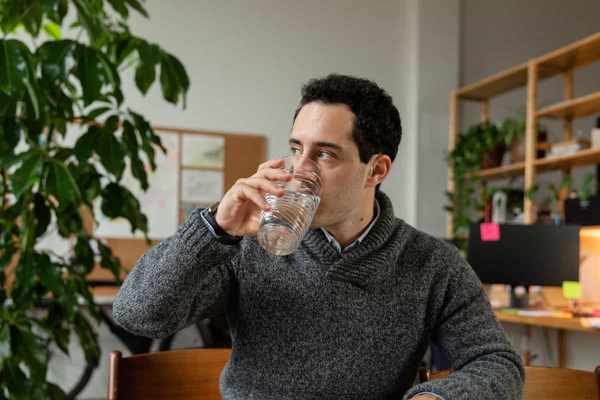 A man drinking water to avoid vape dizziness