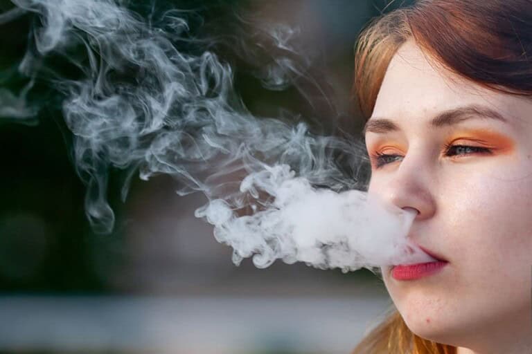 A lady is vaping and getting tired